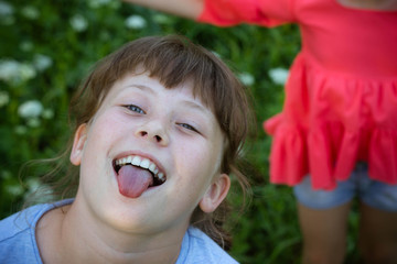 A pretty girl puts out her tongue and has fun. Happy birthday, April 1. A child a girl spoils.