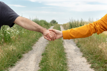 Two entwined hands and a country road in the background