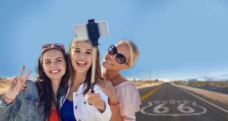 summer vacation, holidays, travel, technology and people concept- group of smiling young women...