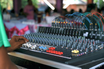 Hand of the sound producer with professional audio mixer and music equipment for sound mixer control, electronic device