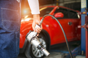 Obraz premium Profesjonalny mechanik, zmiana i regulacja koła samochodowego w warsztacie samochodowym