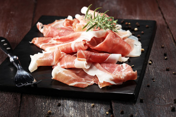 Italian prosciutto crudo or jamon with rosemary. Raw ham