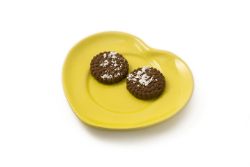 Smiling biscuits on a yellow plate. Morning dessert concept.
