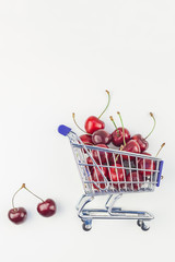 Ripe cherries in a shopping cart isolated