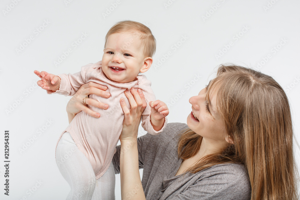 Wall mural mother holding baby girl over white background