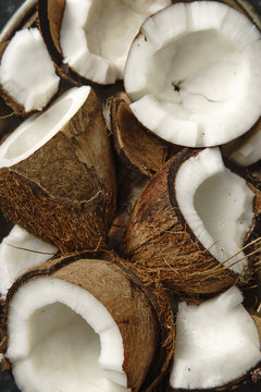 Close up view pf cracked coconuts arranged in metallic tray
