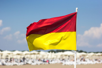 Red yellow flag on the beach. The concept of safety of life.