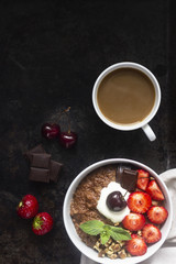 Chocolate oatmeal porridge topped with strawberries, cherries, walnuts and chocolate pieces. The concept of a breakfast. Copy space.