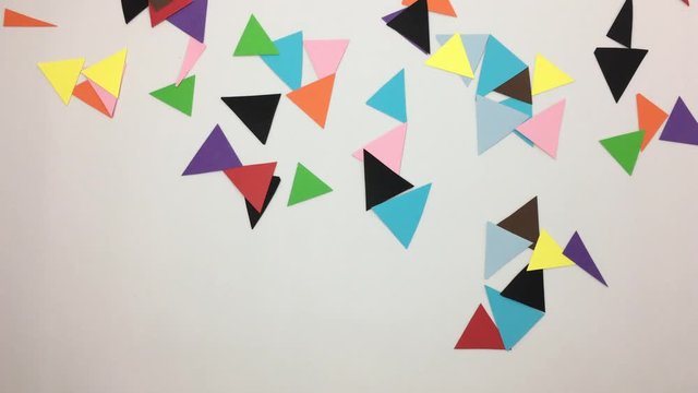 Numero 10 hecho de triangulos de colores se deshace por el viento.