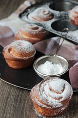 Homemade modern pastries cruffins (like croissant and muffin) with sugar powder served in clay tray.