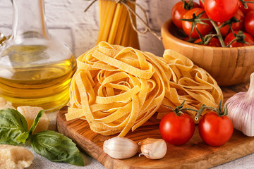 Products for cooking - pasta, tomatoes, garlic, olive oil, basil.