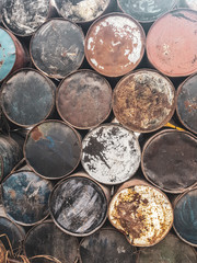Closeup of old rusted colorful barrels from fuel or oil products