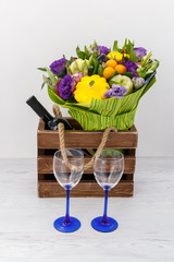 Beautiful bouquet of various vegetables, a bottle of red wine and two glasses on a white background