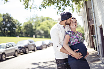 Pregnant couple portrait outside in the neighborhood