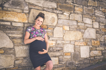 Portrait of a happy and proud pregnant woman on urban background