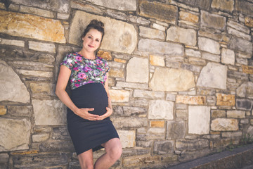 Portrait of a happy and proud pregnant woman on urban background