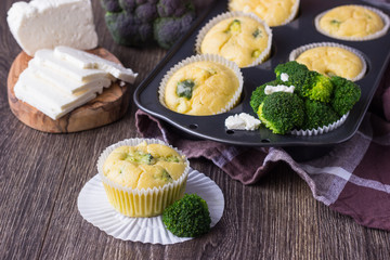 Homemade muffins with broccoli and cheese on wooden background. Healthy snack.