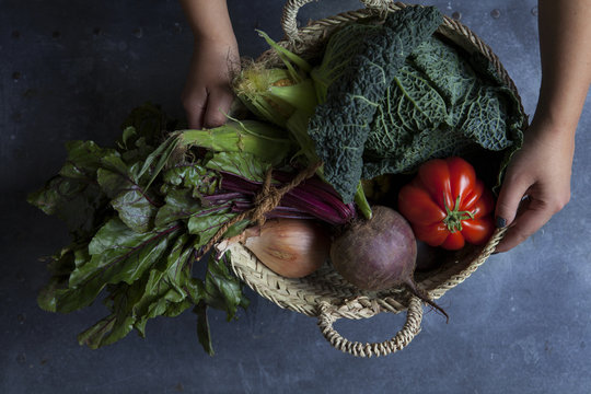 Wicker basket of autumn vegetables with hands