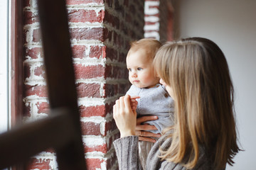 Beautiful young mother with baby girl at home .