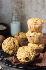 Muffins with chocolate chips (drops) in bakeware (muffin pan) on linen towel. Basic muffin recipe. Homemade muffins for breakfast or dessert.