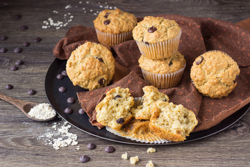 Muffins with chocolate chips (drops) in bakeware (muffin pan) on linen towel. Basic muffin recipe. Homemade muffins for breakfast or dessert.