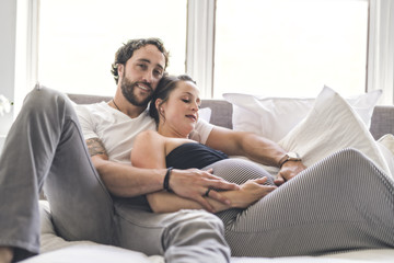 Fototapeta premium Man with pregnant woman in bed at home having great time