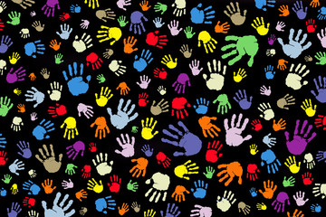 Background of many color prints of hands on a black background