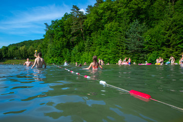 LVIV, UKRAINE - 9 JUNE , 2018: people swimming in lake in sunny summer day.