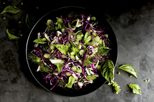 Kale Fennel Salad with Lemon Basil Pesto Vinaigrette photographed on a black background.