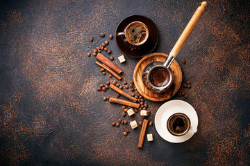 Cups of coffee, beans, sugar and cinnamon