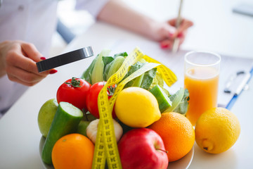 Diet. Fitness and healthy food diet concept. Balanced diet with vegetables. Fresh green vegetables, measuring tape on white background. Closeup
