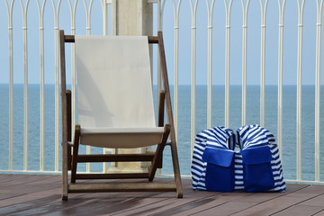 Sonnenliege und Strandtasche auf der Dachterrasse am Meer