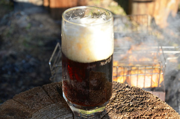 cold beer on desk and grill time in forest
