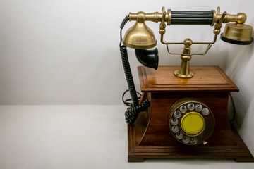 Fototapeta na wymiar Wood and brass vintage phone on white background