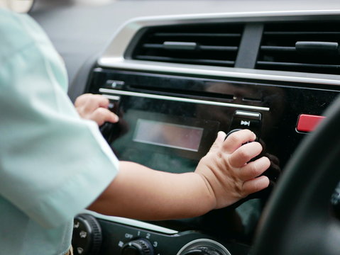 Baby Girl's Hand And Fingers Holding, Touching, And Turning A Car Audio Player Button - Babies Are Naturally Curious And Continually Engage In Cause-and-effect Exploration And Play