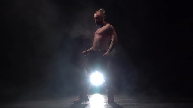 Guy dances erotic movements. Smoke background. Slow motion