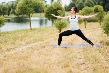 Young girl doing yoga in morning park.Woman Yoga - relax in nature