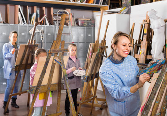 Students working patiently during painting class at art studio