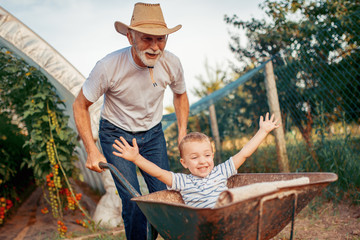 Happy grandfather and his grandson having fun together
