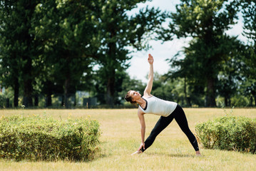 Fototapeta na wymiar Young girl doing yoga in morning park.Woman Yoga - relax in nature