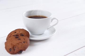 A cup of fragrant coffee with milk and cookies on the white background. Shortbread cookies with slices of chocolate and white cup of coffee.