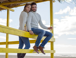 Fototapeta premium young couple drinking beer together at the beach