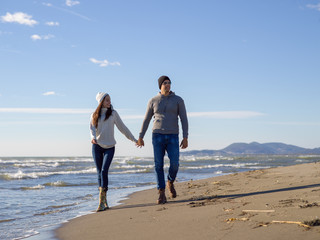 Loving young couple on a beach at autumn sunny day