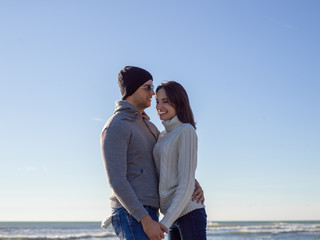 Loving young couple on a beach at autumn sunny day