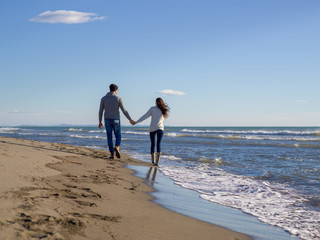 Loving young couple on a beach at autumn sunny day
