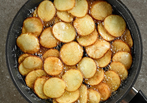 frying potatoes in pan with oil