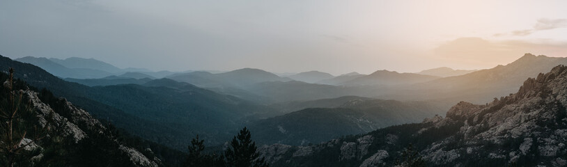 Abenddämmerung mit Ausblick auf nebelige Berge bei Sonnenaufgang - obrazy, fototapety, plakaty