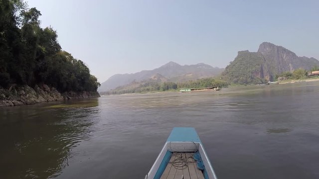 Crossing the Mekong river in a wodden banana boat near Pak Ou Caves north of Luang Prabang