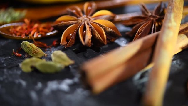 Spices. Various Indian spices on a dark stone table. Spice and herbs on black background. Dolly shot. Slow motion. 3840X2160 4K UHD video footage