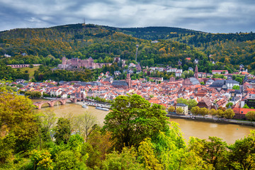 Fototapeta na wymiar View on Heidelberg in autumn with red foliage including Carl Theodor Old Bridge, Neckar river, Church of the Holy Spirit, Germany